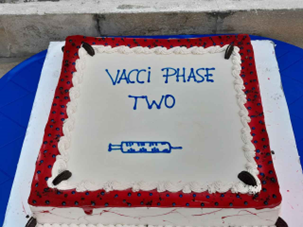 Kuchen mit Aufschrift "Vacci Phase Two" und einer Spritze.