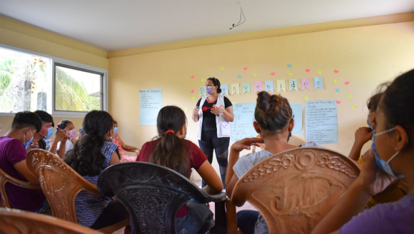 Eine Mitarbeiterin im Gespräch mit Jugendlichen in Honduras.
