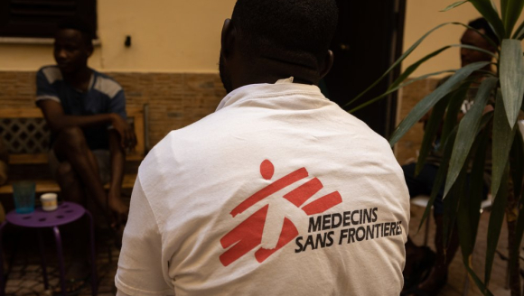Migrant*innen im Gespräch mit MSF-Mitarbeiter Moussa Zarre.