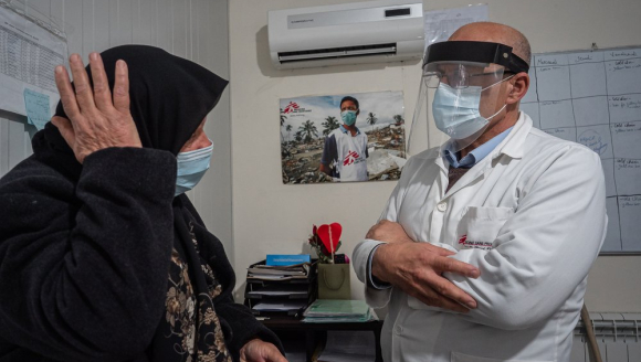 Eine Frau auf einer Krankenliege redet mit einem Arzt von Ärzte ohne Grenzen