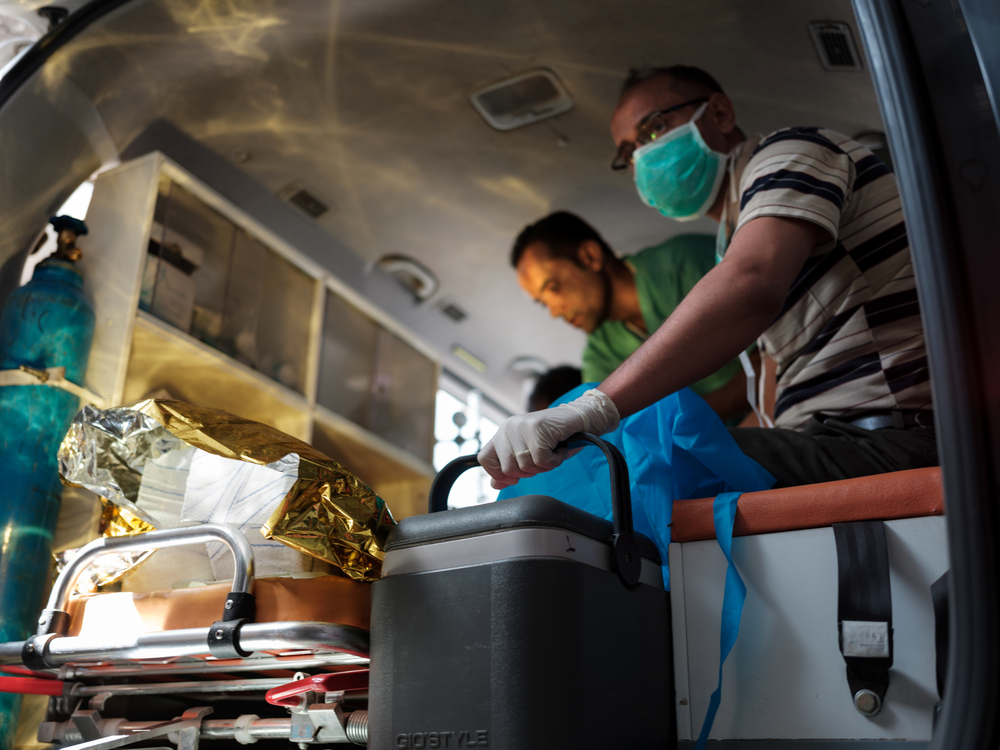 Mitarbeitende bereiten einen Patienten auf den Transport in eine andere Klinik vor.