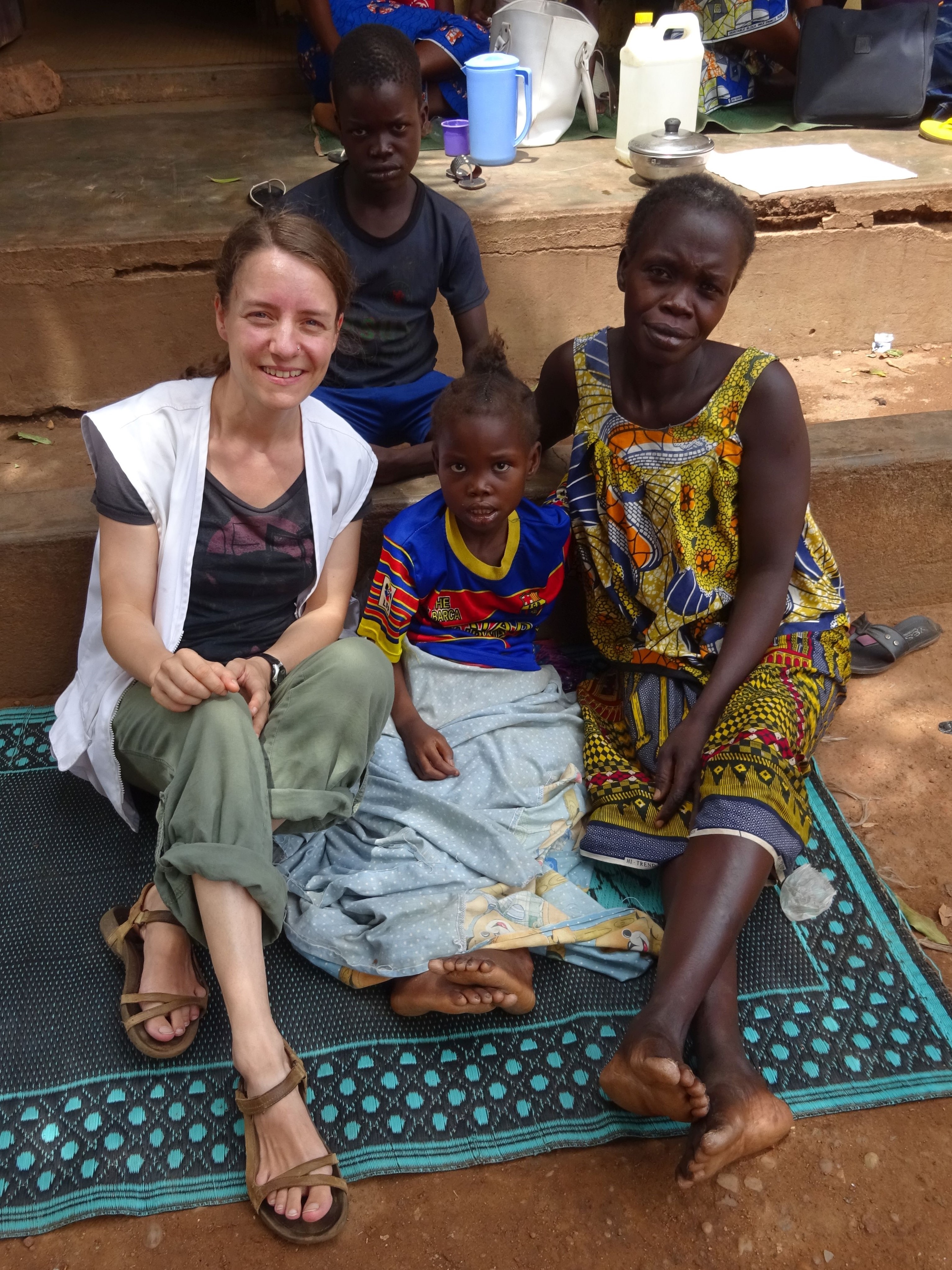 Anästhesistin Roberta Rehnig sitzend mit Patient*innen in der Zentralafrikanischen Republik