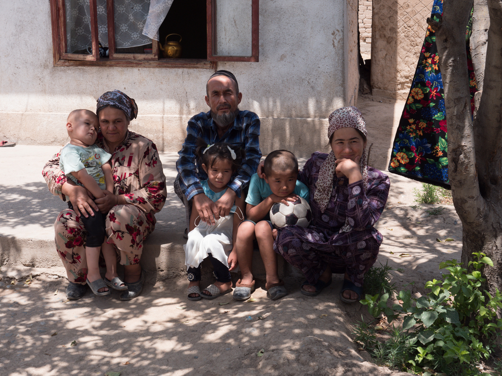 Eine Familie sitz vor ihrem Haus in Tadschikistan