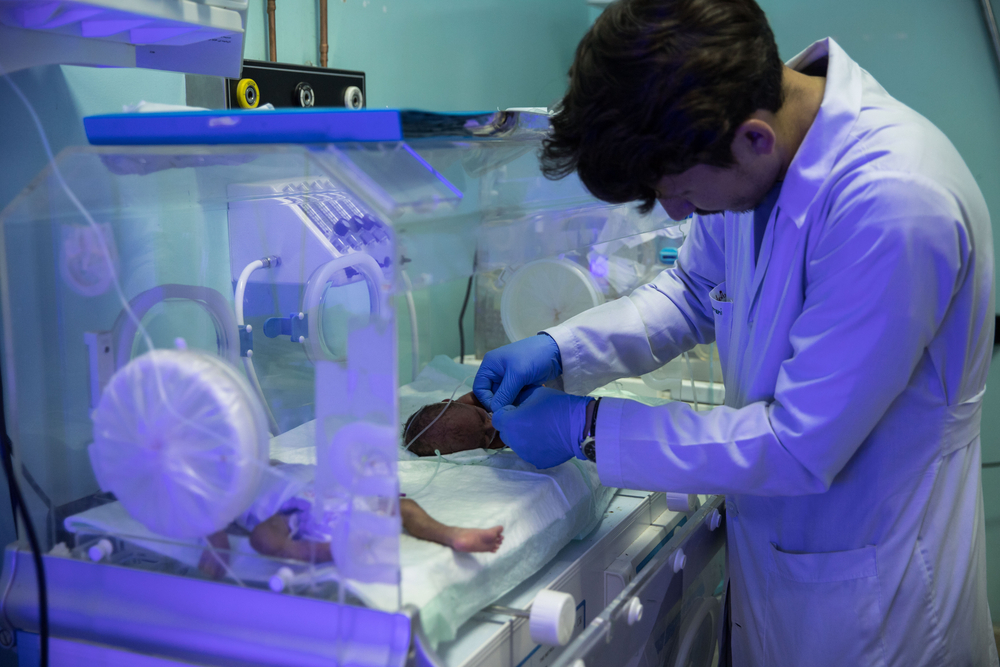 Ein Pfleger prüft die Beatmung eines Frühgeborenen Babys