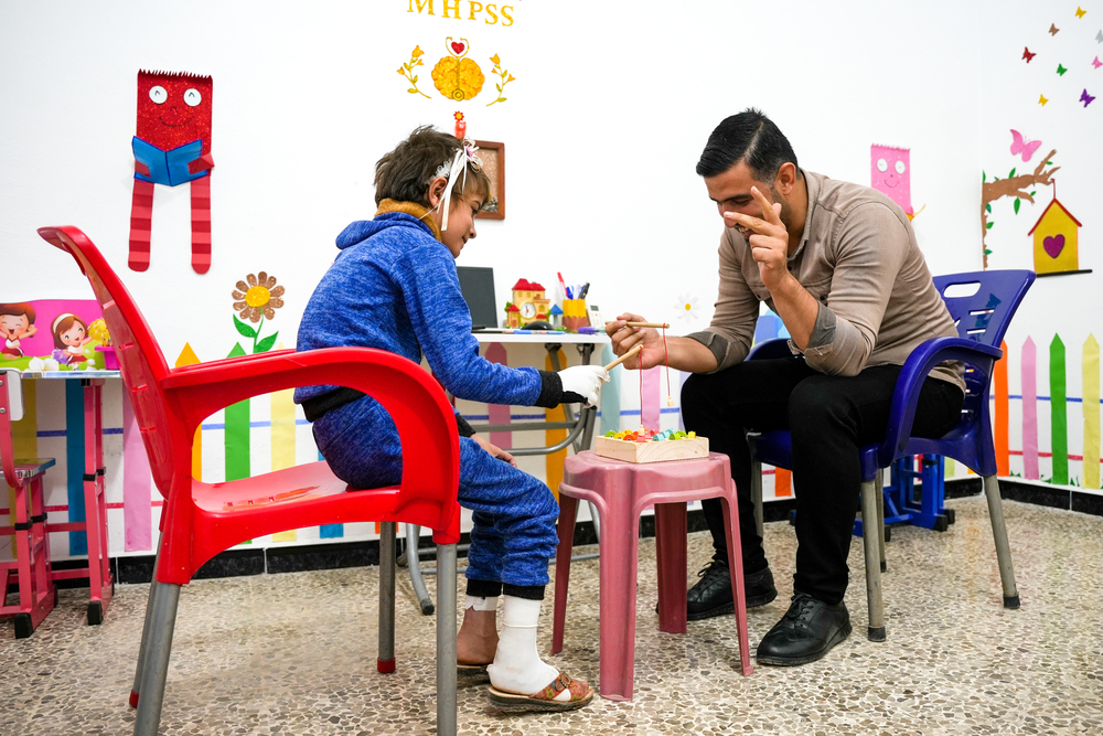 Mitarbeiter und Kind spielen miteinander