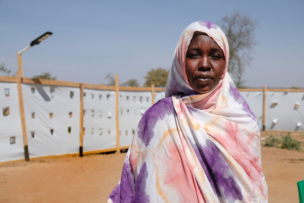 Nadia Omar Mohammad vor Plastikwand in Geflüchtetencamp