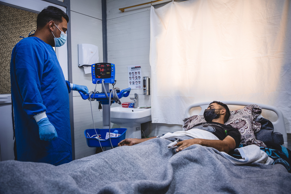 Ein Krankenpflegeri behandelt einen unserer Patient*innen in Mossul. 