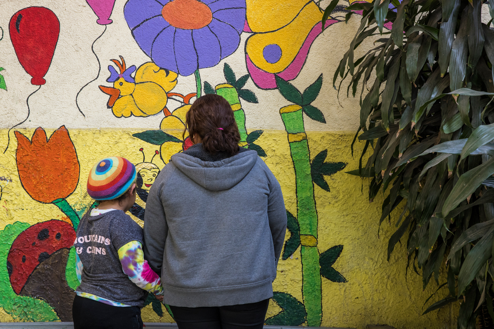 Mexiko: Mutter und Tochter vor Wandgemälde