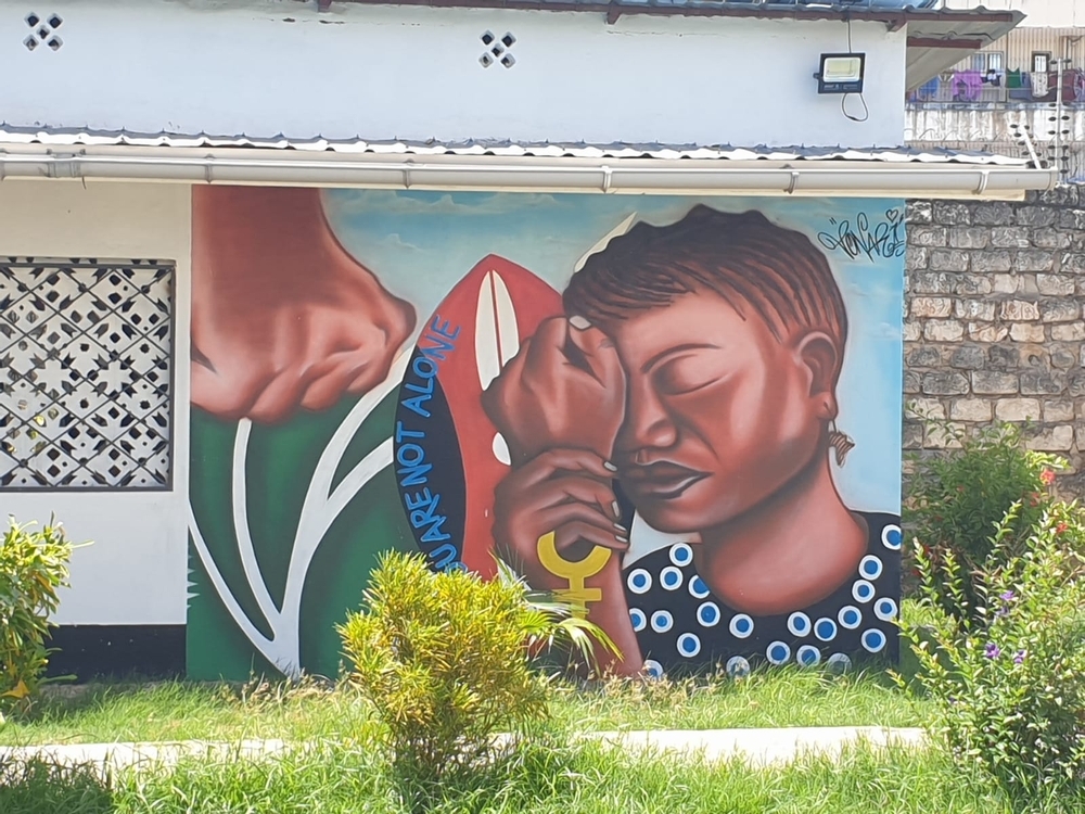 Wandgemälde von dem Gesicht einer Frau und der Aufschrift "You Are Not Alone" 