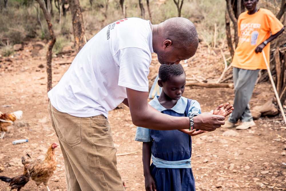 Ein Mitarbeiter begutachtet die durch einen Schlangenbiss entstandene Wunde eines Kindes. 