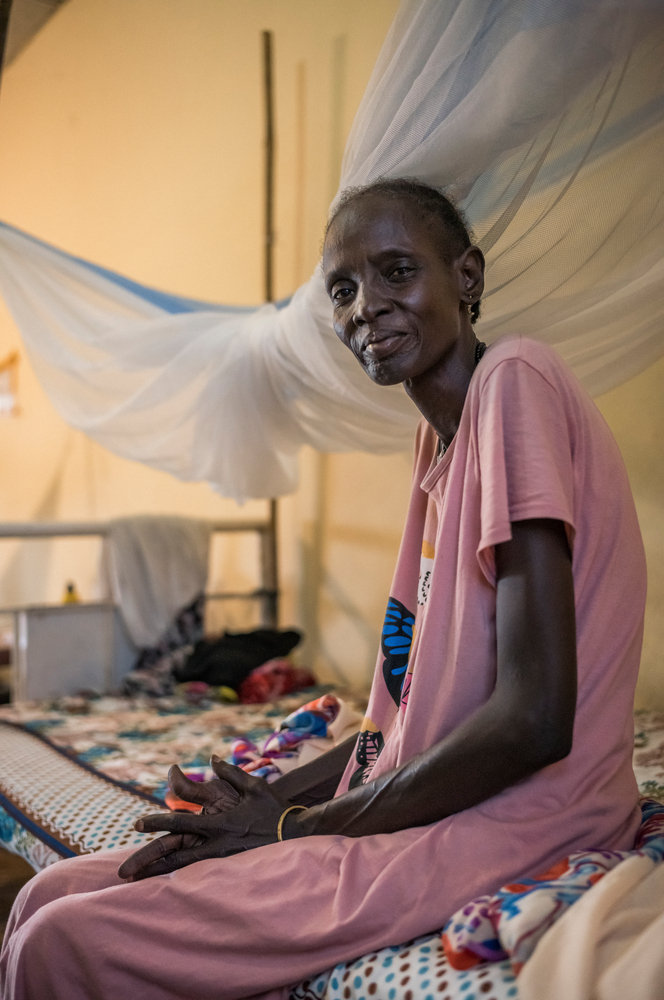 Frau sitzt auf Krankenhausbett