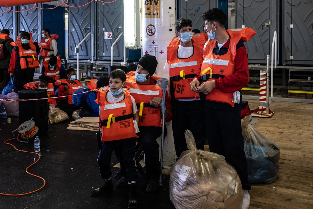 Eine Familie sitzt mit Rettungswesten an Board eines Schiffes