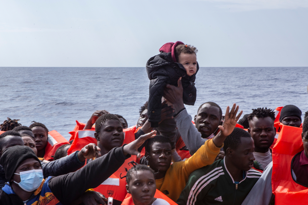 Ein Baby wird von einem kleinen Boot an Board der Geo Barents gerettet