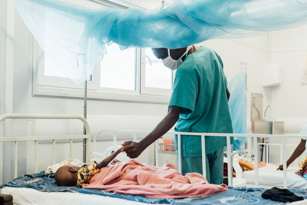 Eine Krankenpflegerin betreut ein 2-jähriges Kind