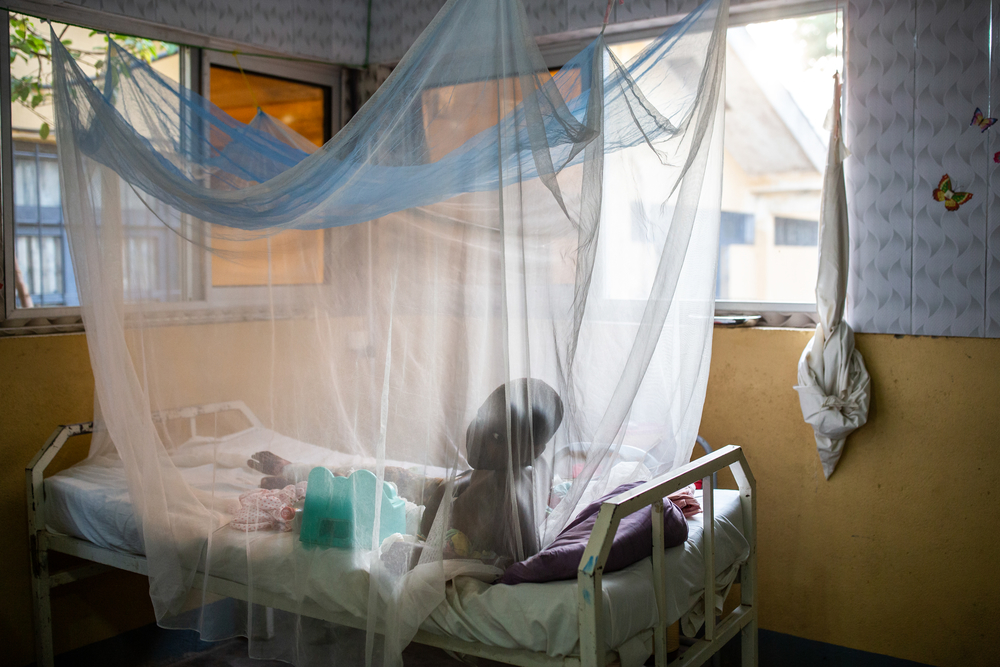 Kind in einem Krankenhausbett mit Moskitonetzen 