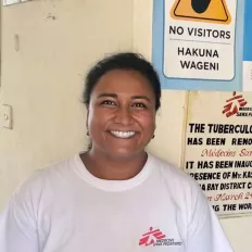 Foto von der Ärztin Sayontonee Ghosh, sie steht zentral im Bild und lächelt