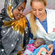 Hebamme Julia Falkner und Mutter mit ihrem Kind.