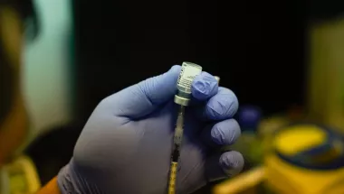 Impfstoff wird aus einer Ampulle in einer Spritze aufgezogen.