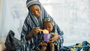 Eine Mutter füttert ihre 2-jährige Tochter auf der Mangelernährungsstation in einem Krankenhaus in Niger