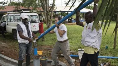 Drei Techniker*innen installieren eine Wasserpumpe in Nigeria.