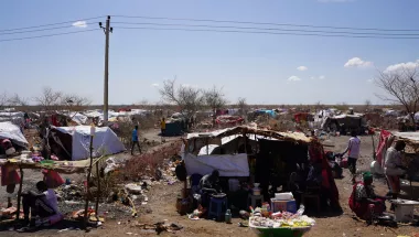 Ein Camp aus provisorischen Zeltunterkünften mit Menschen