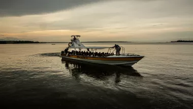 Menschen in einem Kahn auf einem breiten Fluss