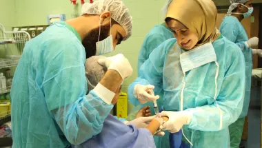 Lächelnde Anästhesistin spritzt Kind ein Medikament