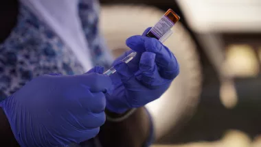 Masernimpfung wird aus Ampulle von Mitarbeiter entnommen.