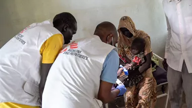 Zwei Mitarbeiter behandeln ein Kind.