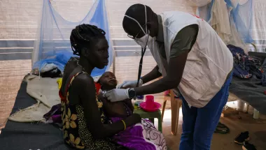 Eine Mutter hält bei der Untersuchung ihr an Tuberkulose erkranktes Kind im Arm.