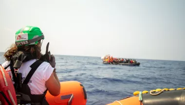 Mitarbeitende auf Schlauchboot spricht in Funkgerät