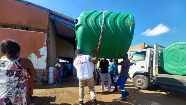 Eine große Wassertonne wird von einem Lastwagen gehoben