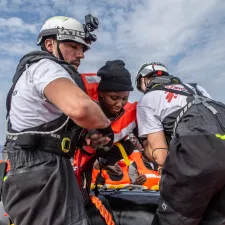 Zwei Mitarbeiter von Ärzte ohen Grenzen helfen den Menschen an Board der Geo Barents zu kommen