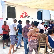 Migranten warten vor einer mobilen Klinik