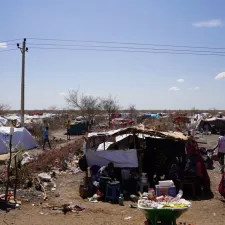 Ein Camp aus provisorischen Zeltunterkünften mit Menschen