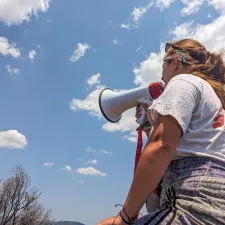 Eine Person von hinten in Ärzte ohne Grenzen Shirt mit Megaphone