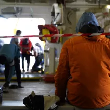 Bild in Schiff mit Mitarbeitenden und Geretteten im Hintergrund