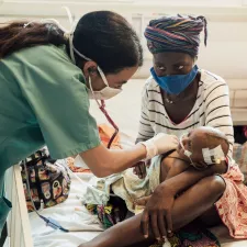 Ärztin Marianella Rodríguez untersucht eine sehr junge Patient*in auf der Intensivstation eines Krankenhauses in Sierra Leone. Ärztin untersucht Baby auf Intensivstation