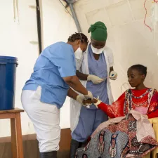 Unsere Pflegerinnen versorgen eine Patientin im Triage-Zelt unseres Cholera-Behandlungszentrums in Bujumbura, Burundi. Wir übernehmen die Diagnose und Erstversorgung der Patient*innen. Pflegerinnen versorgen Patientin in Cholera-Behandlungszelt