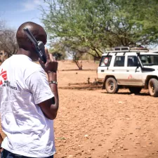 Mitarbeitender telefoniert mit Satellitentelefon Mitarbeitender telefoniert mit Satellitentelefon