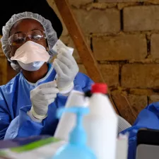 Eine Person in Schutzkleidung bereitet eine Ebola-Impfung vor.