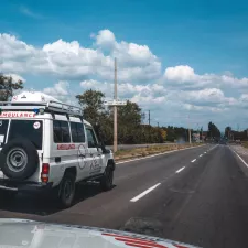 Ein weißer Krankenwagen mit dem Logo von Ärzte ohne Grenzen fährt auf einer Straße.