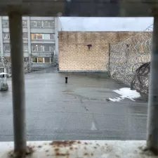 Gitterstäbe vor einem Dach, das mit Stacheldrahtzaun gesichert wurde