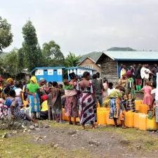 Die Bewohner*innen der Geflüchtetenunterkunft warten darauf, ihre Kanister mit Trinkwasser zu füllen 