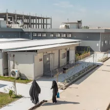 Der Krankenhauskomplex aus der Vogelperspektive mit zwei Frauen die auf den Eingang zu laufen