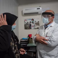 Eine Frau auf einer Krankenliege redet mit einem Arzt von Ärzte ohne Grenzen