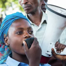 Frau mit Megaphone in der Demokratischen Republik Kongo