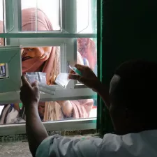 Eine Frau erhält ihre Medikamente durch ein Fenster.