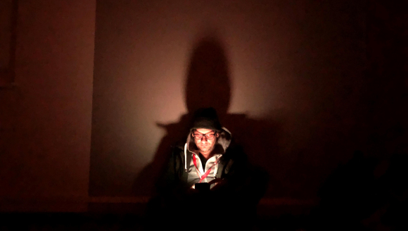 Oliver Barth schut in einem dunklen Luftschutzkeller auf sein Handy