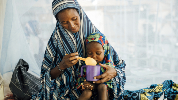 Eine Mutter füttert ihre 2-jährige Tochter auf der Mangelernährungsstation in einem Krankenhaus in Niger